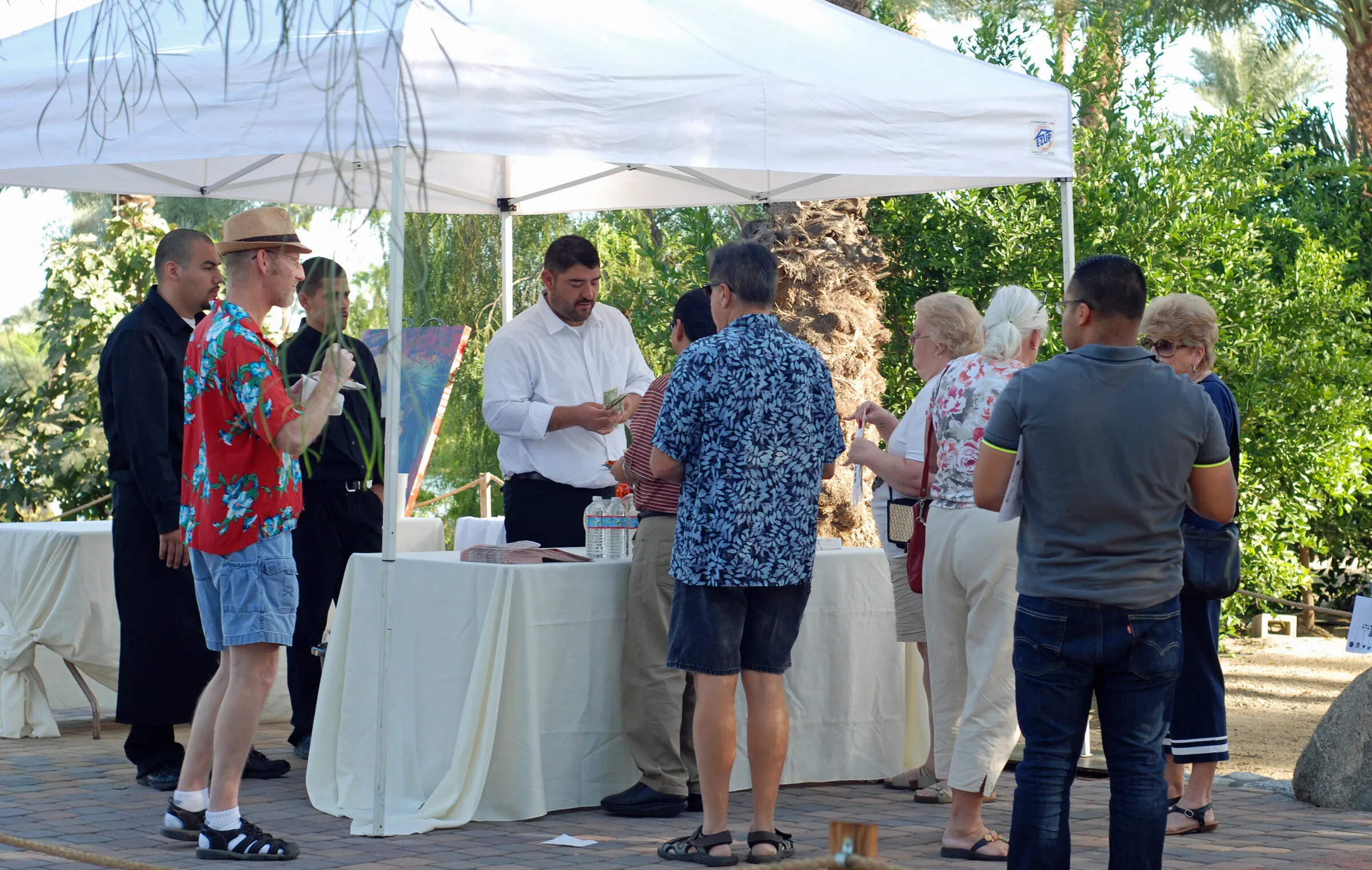 Guests gathered at an outdoor reception table under a white canopy