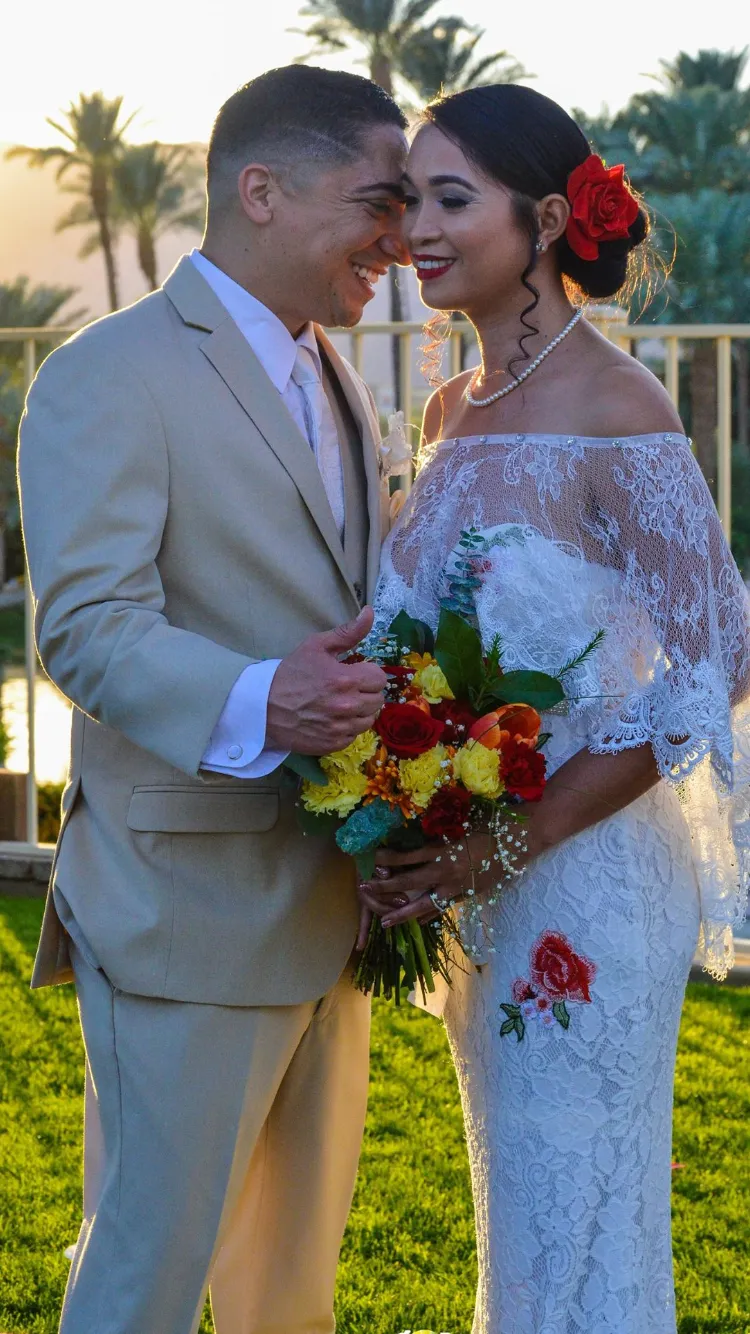 Smiling bride and groom embracing at sunset in the palm garden